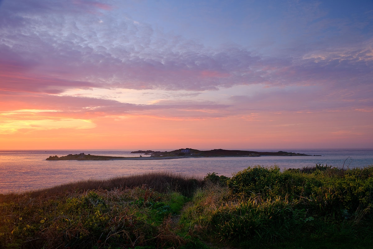 Beautiful coloured clouds at sunset overlooking Lihou Island, Guernsey, viewed from L'Eree headland.