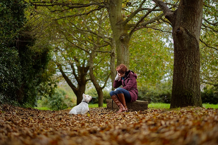 Portrait of young woman and her dog in Autumn woodland.