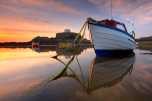 A fishing boat moored at the Cup and Saucer at sunset.