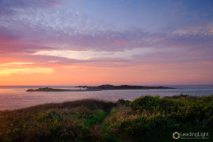 Beautiful coloured clouds at sunset overlooking Lihou Island, Guernsey, viewed from L'Eree headland.