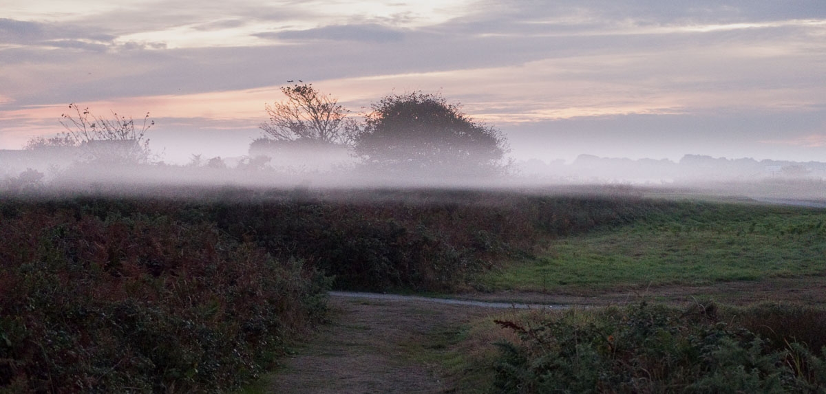 A thin layer of fog develops above the ground at L'Ancresse Common, Guernsey, at sunset.