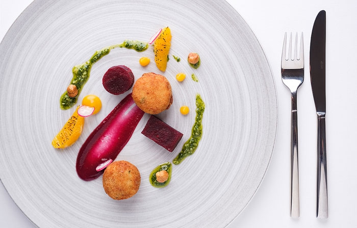 Food photography - colourful starter on a plate with cutlery.