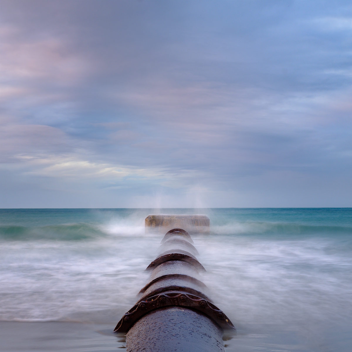 Dreamy abstract of an outfall pipe at Vazon Bay, Guernsey, with a square crop.