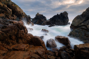 Winter waves crash through a gap in the rocks at Le Jaonnet Bay, Guernsey.