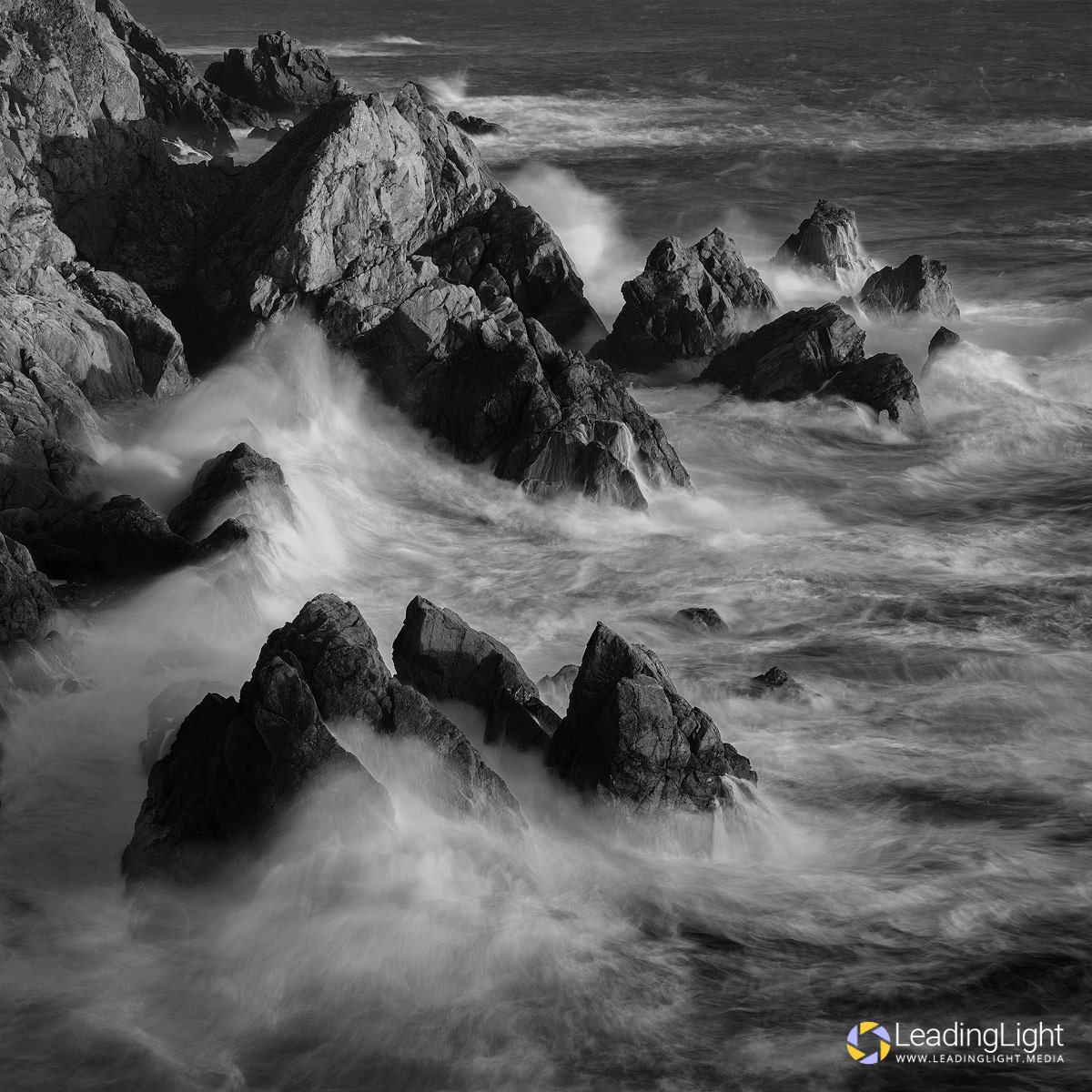 A re-shoot of an award-winning black and white photograph from 15 years ago. Stormy seas ravage rocks at Les Tielles, Guernsey.
