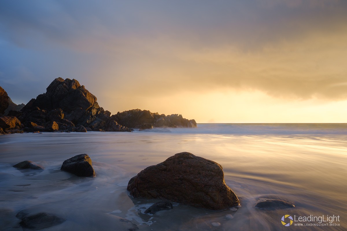Intense warm sunset light bathes Le Jaonnet Bay, Guernsey, after a heavy rain shower